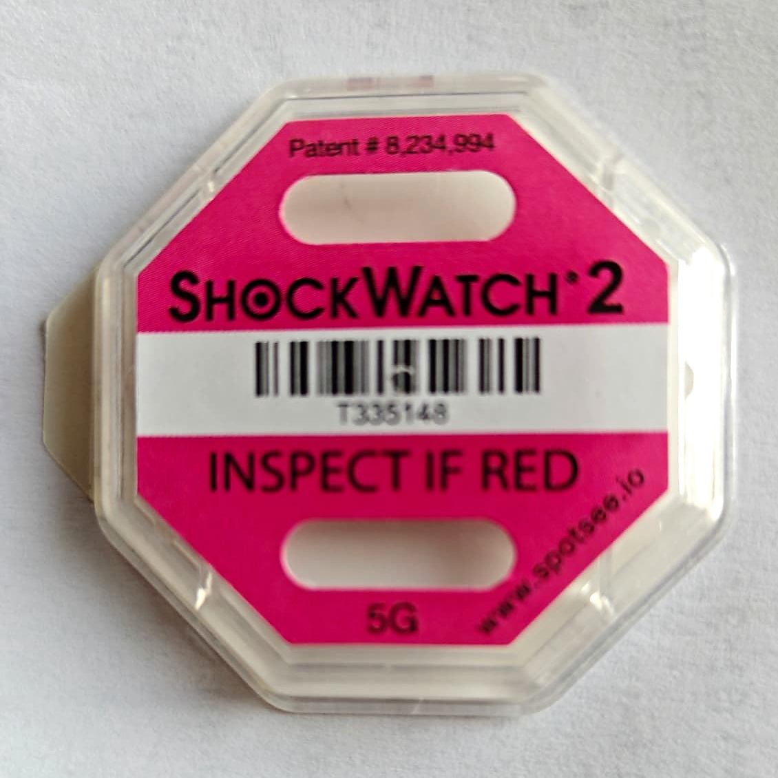 Indikátor nárazu ShockWatch 2 před spuštěním — bílé okénko, nápis INSPECT IF RED
